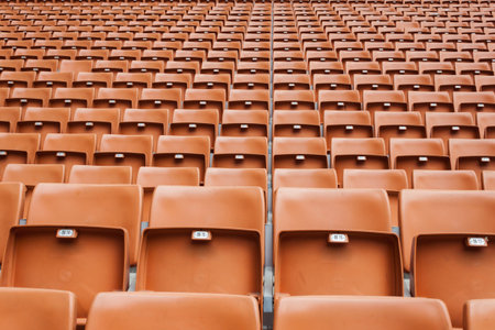 Perspective of many empty orange stadium seats