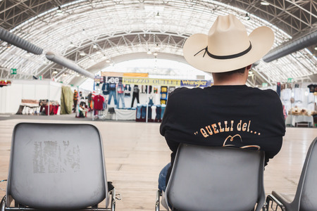 MILAN, ITALY - JUNE 22  Guy with cowboy hat sitting at Rocking The Park, event dedicated to American music and lifestyle of the 40s, 50s and 60s on JUNE 22, 2014 in Milan のeditorial素材