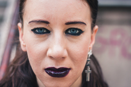 Closeup of a pretty dark goth girl posing in urban landscapeの写真素材