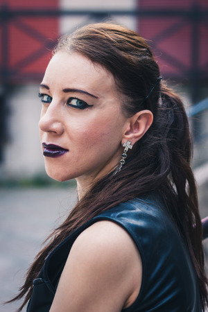 Closeup of a pretty dark goth girl posing in urban landscapeの写真素材