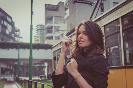 Pretty girl with long hair poses in the city streets