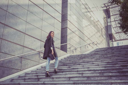Pretty girl with long hair poses in the city streetsの写真素材