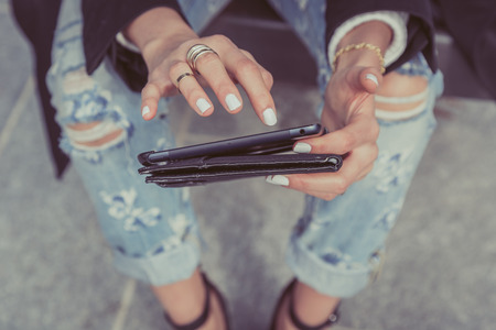Detail of a girl works with her tablet in the city streetsの写真素材