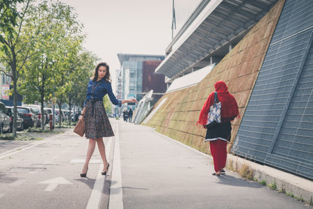 Pretty girl with long hair poses in the city streetsの写真素材