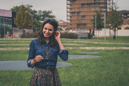 Pretty girl with long hair poses in the city streetsの写真素材
