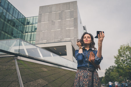 Pretty girl with long hair poses in the city streets