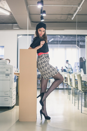 Beautiful young brunette with turban posing in an officeの写真素材