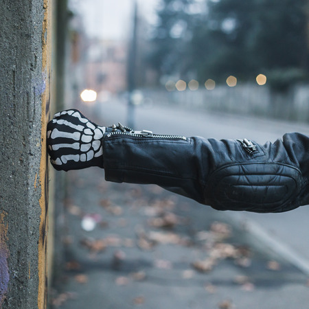 Detail of a punk guy with gloves posing in the city streetsの写真素材