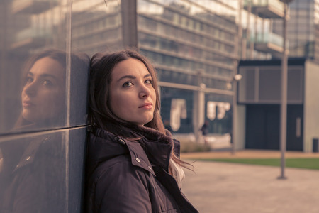 Young beautiful girl with long hair posing in the city streetsの写真素材