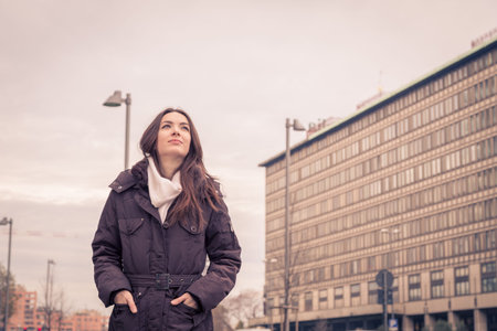 Young beautiful girl with long hair posing in the city streets