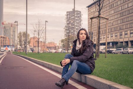 Young beautiful girl with long hair posing in the city streetsの写真素材
