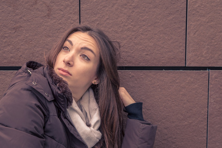 Young beautiful girl with long hair posing in the city streetsの写真素材