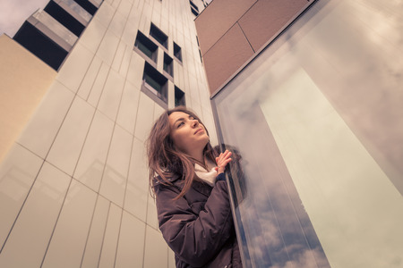 Young beautiful girl with long hair posing in the city streetsの写真素材