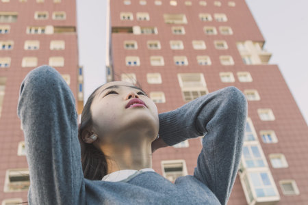 Young beautiful Chinese girl with long hair posing in the city streetsの写真素材