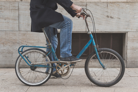 Detail of a young man posing with his bicycle in the city streetsの写真素材