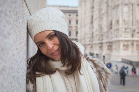 Beautiful young woman wearing ecological fur poses in the city streetsの写真素材