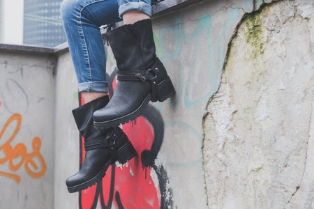 Detail of a young woman wearing black leather biker boots
