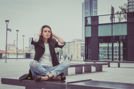 Pretty girl with long hair poses in the city streets