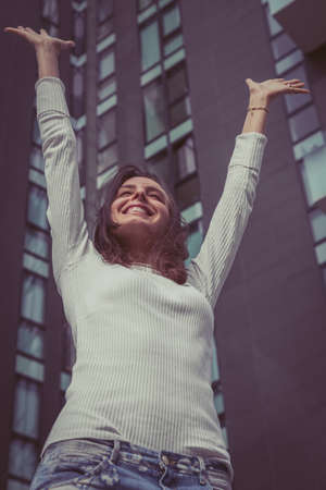 Pretty girl with long hair poses in the city streetsの写真素材