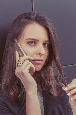 Pretty girl talks on phone in the city streets