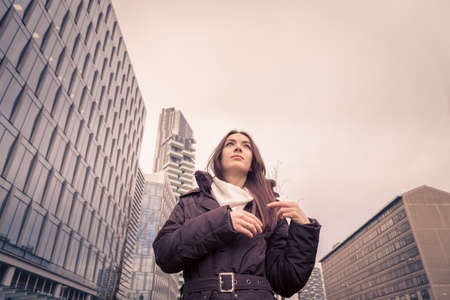 Young beautiful girl with long hair posing in the city streetsの写真素材