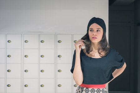 Beautiful young brunette with turban posing in an office