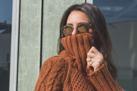 Beautiful girl with long hair posing in an urban contextの写真素材