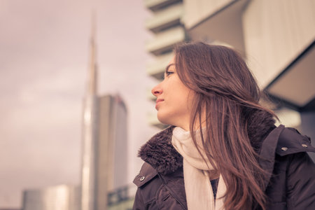 Young beautiful girl with long hair posing in the city streets