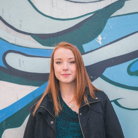 Beautiful young redhead girl posing in the city streetsの写真素材