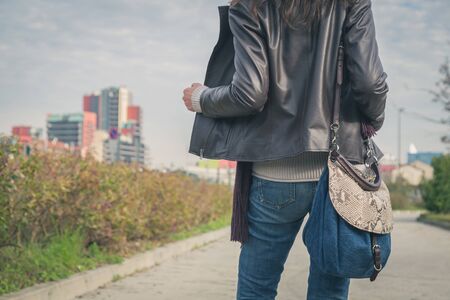 Detail of a young woman with bag posing in the city streetsの写真素材