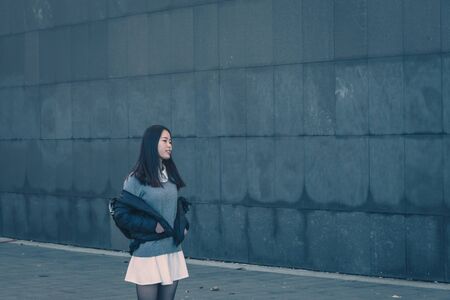 Young beautiful Chinese girl with long hair posing in the city streetsの写真素材