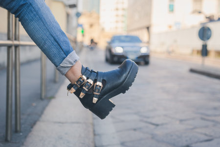 Detail of a young girl in jeans posing in an urban context