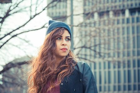 Beautiful Middle Eastern girl with long hair posing in an urban contextの写真素材