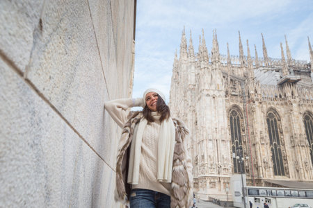Beautiful young woman wearing ecological fur poses in the city streetsの写真素材