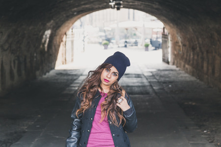 Beautiful Middle Eastern girl with long hair posing in a tunnelの写真素材
