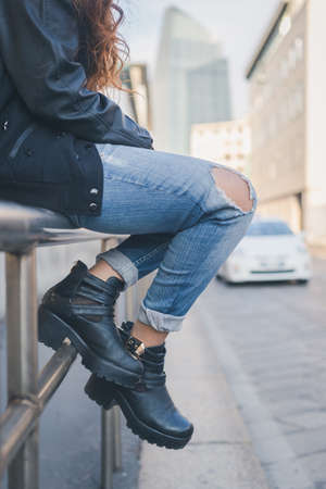 Detail of a young girl in jeans posing in an urban contextの写真素材