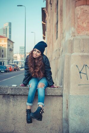 Beautiful Middle Eastern girl with long hair posing in an urban contextの写真素材