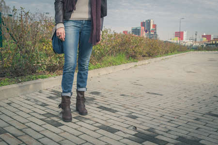 Detail of a young woman with bag posing in the city streetsの写真素材