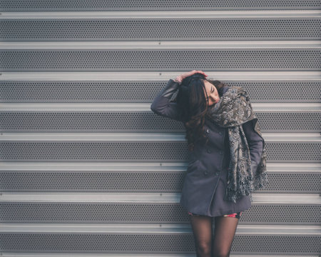 Beautiful young brunette with long hair posing in an urban context
