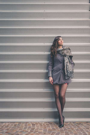 Beautiful young brunette with long hair posing in an urban contextの写真素材