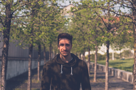 Young handsome man with short hair posing in an urban contextの写真素材