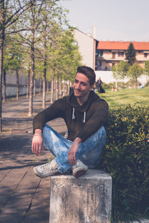 Young handsome man with short hair posing in an urban contextの写真素材