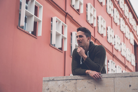 Young handsome man with short hair posing in an urban contextの写真素材