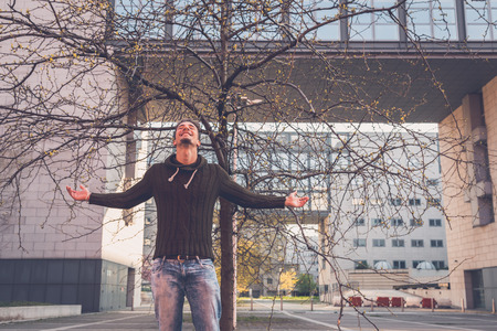 Young handsome man with short hair posing in an urban contextの写真素材