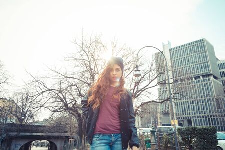 Beautiful Middle Eastern girl with long hair posing in an urban context. Backlight.の写真素材