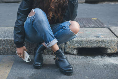 Detail of a young girl in jeans posing in an urban contextの写真素材