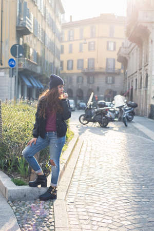 Beautiful Middle Eastern girl with long hair posing in an urban context. Backlight.の写真素材