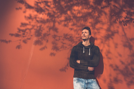 Young handsome man with short hair posing in an urban contextの写真素材