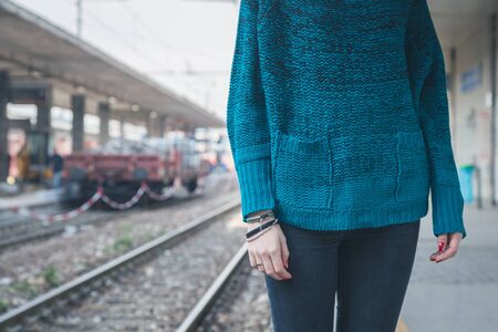 Detail of a young girl posing in a railroad stationの写真素材