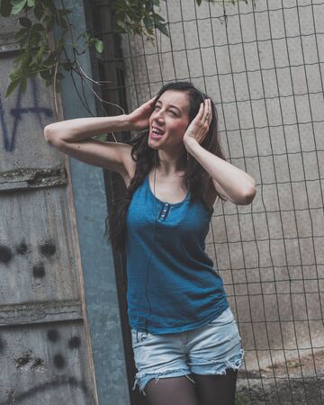 Beautiful girl with long hair posing in the city streetsの写真素材